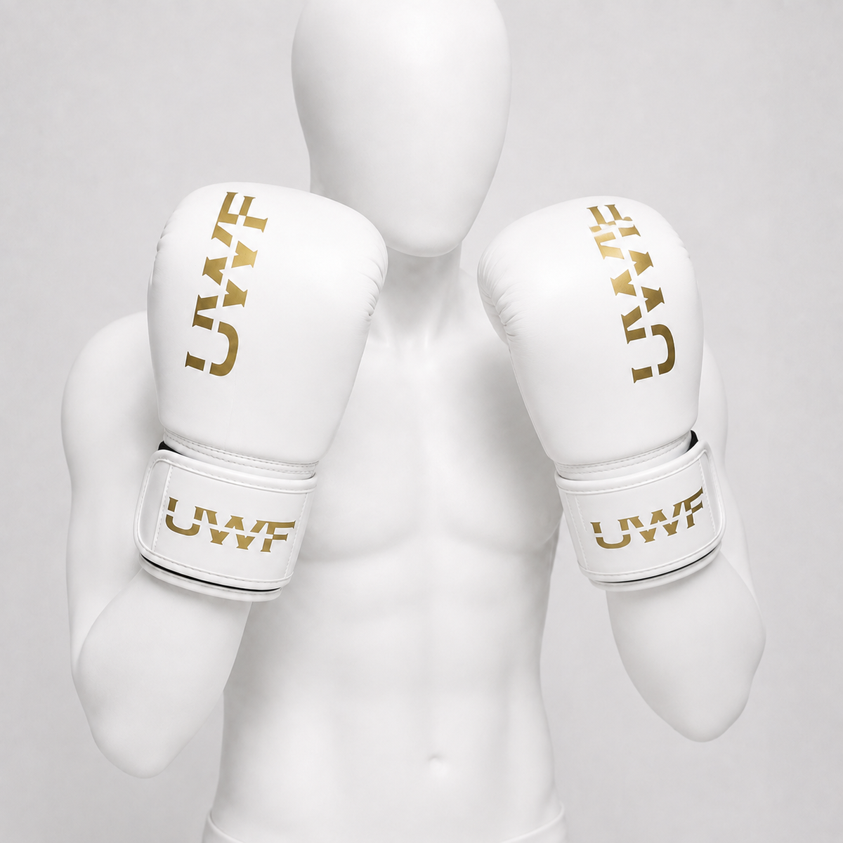 Gants de boxe UWT blanc et or portés dans le bon sens par un mannequin blanc sans visage