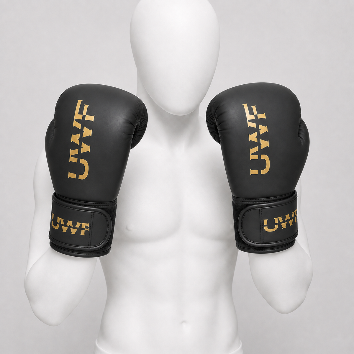 Gants de boxe UWT noir et or portés dans le bon sens par un mannequin blanc sans visage